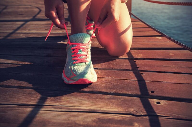 49801846-young-fitness-woman-tying-shoelace-on-seaside-wooden-boardwalk